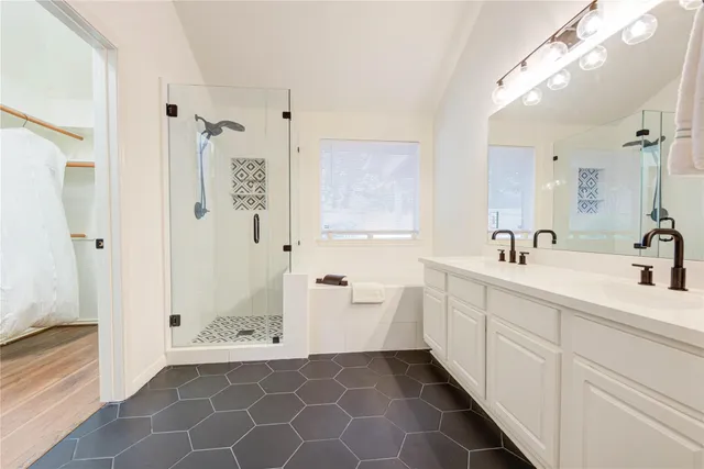 a spacious bathroom with a double vanity sink a mirror and a shower