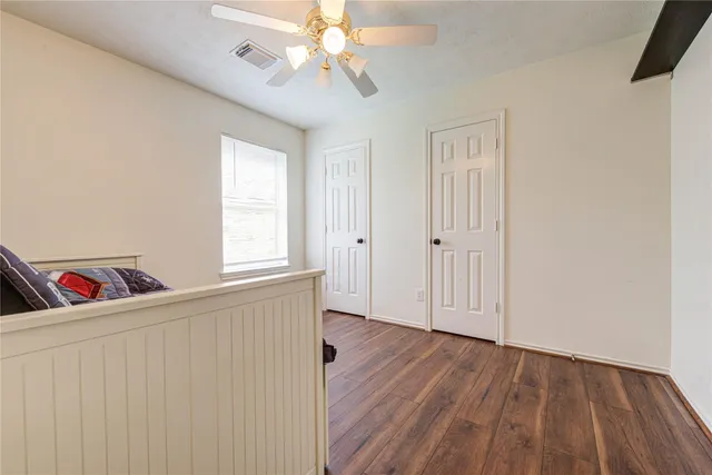 a view of a livingroom with wooden floor and a chandelier fan