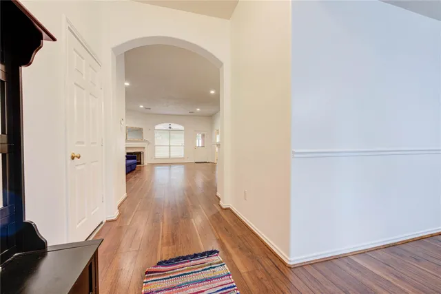 a view of a hallway with wooden floor and staircase