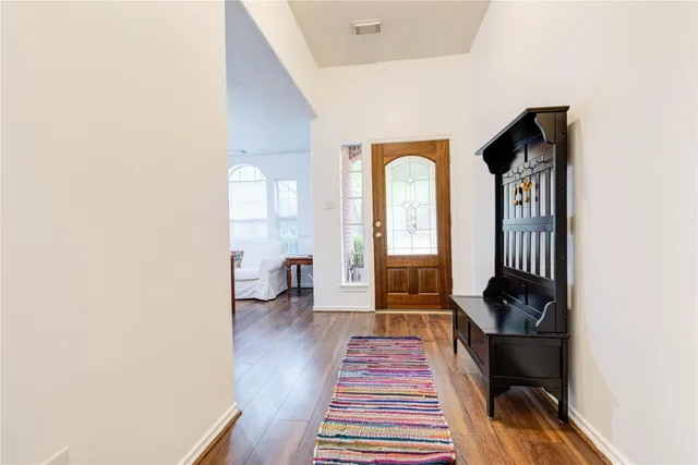 a view of a hallway with wooden floor and staircase