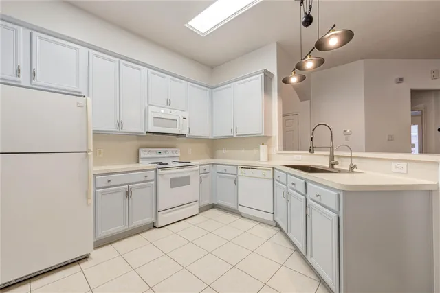 a kitchen with cabinets appliances and a sink
