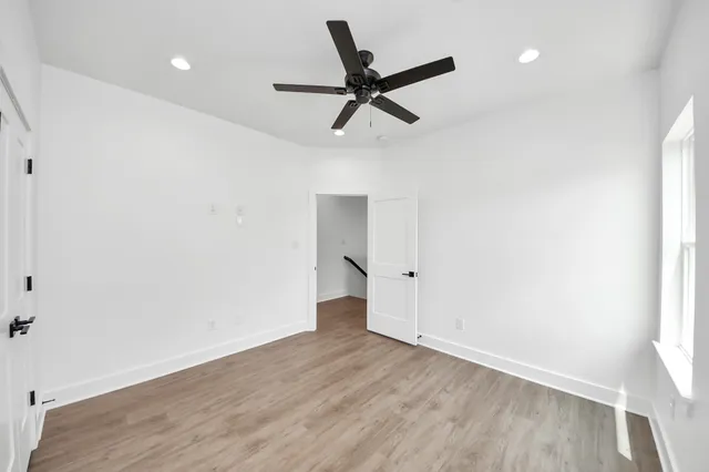 a view of a room with wooden floor and ceiling fan