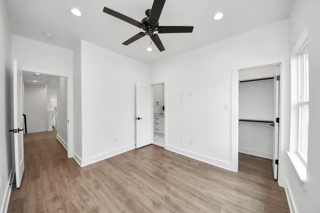 a view of empty room with wooden floor and ceiling fan