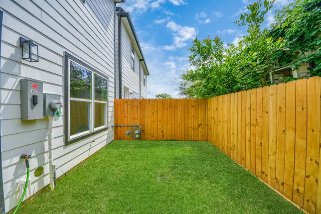 a view of a back yard with a wooden fence
