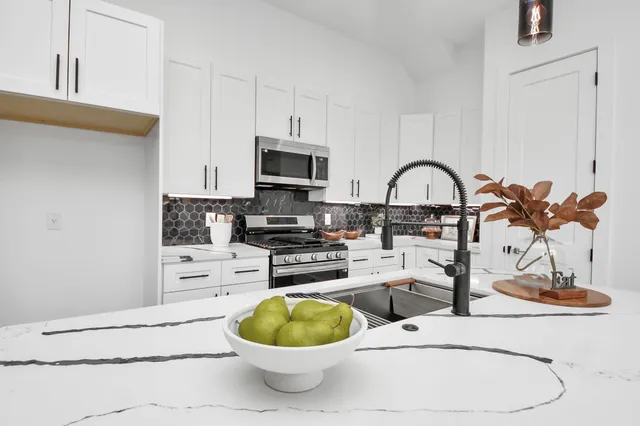 a kitchen with a stove a sink and a microwave