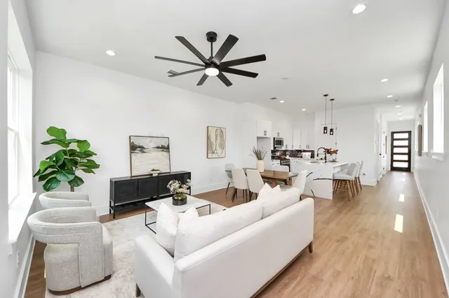 a living room with furniture and a wooden floor