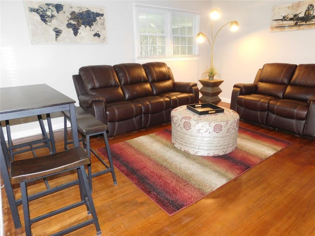 507 Pineridge Road Forest Park, GA 30297 - Photo 8 of 14 a living room with furniture a flat screen tv and a floor to ceiling window