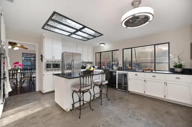 a living room with white cabinets and entryway with wooden floor