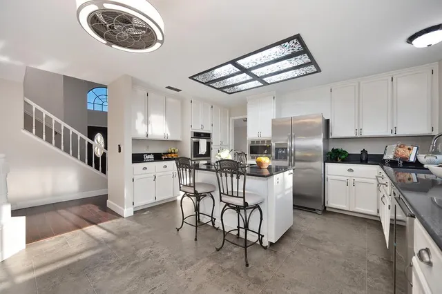 a spacious bedroom with a bed and a chandelier