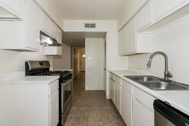 a kitchen with stainless steel appliances granite countertop a sink stove and refrigerator