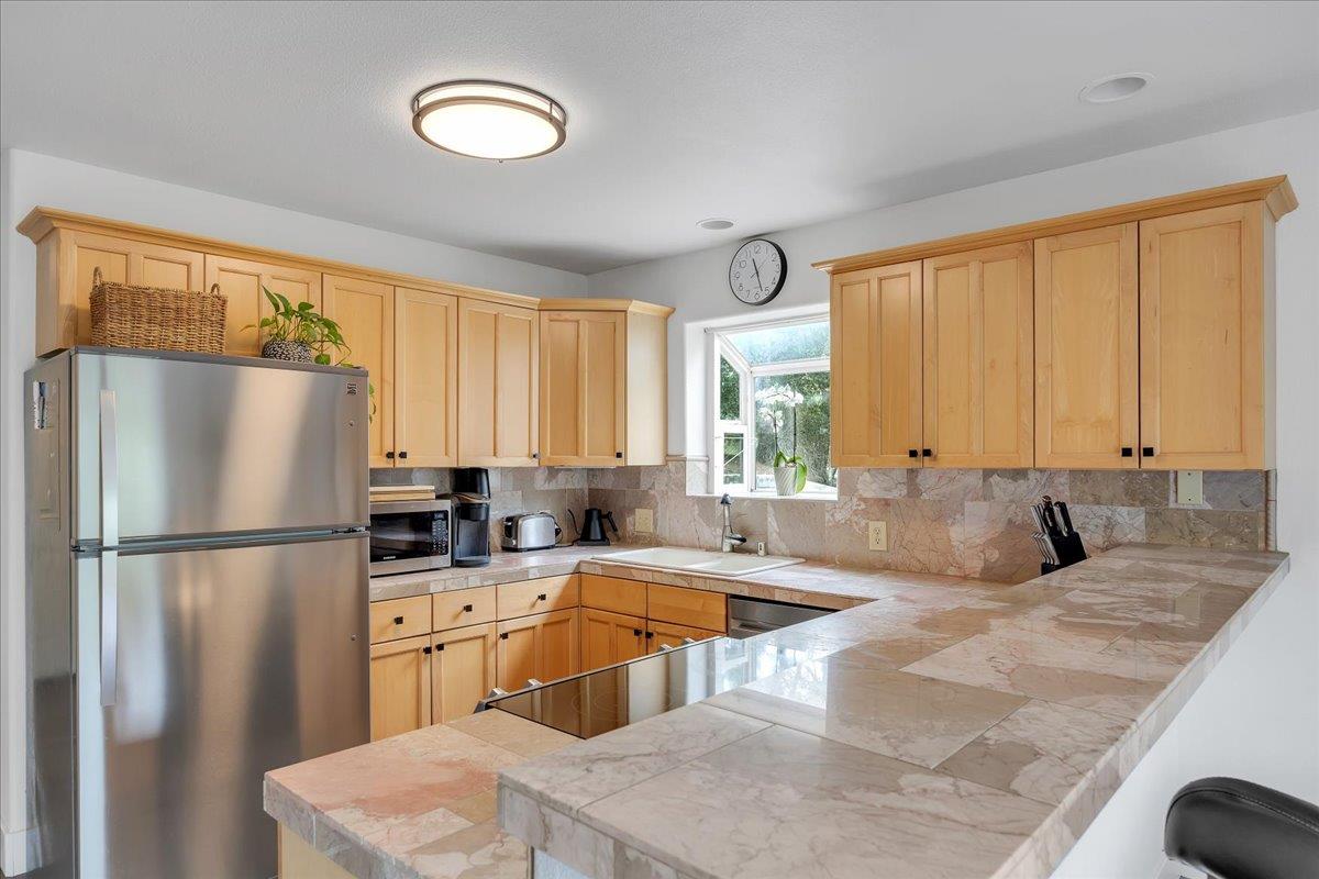 4589 Tomahawk Trail Copperopolis, CA 95228 - Photo 11 of 86 Stone tile counters and backsplash and solid wood cabinetry.