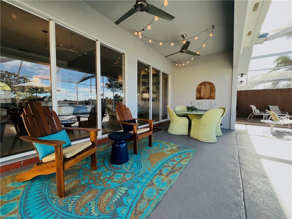 5477 Freeport Lane Naples, FL 34119 - Photo 24 of 36 a living room with patio furniture and a flat screen tv
