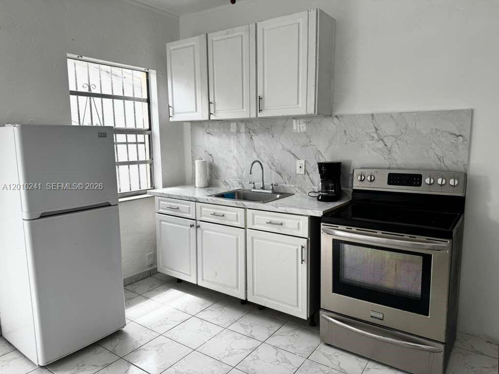 5629 Southwest 7th Street Miami, FL 33144 - Photo 12 of 15 a kitchen with a stove top oven and sink
