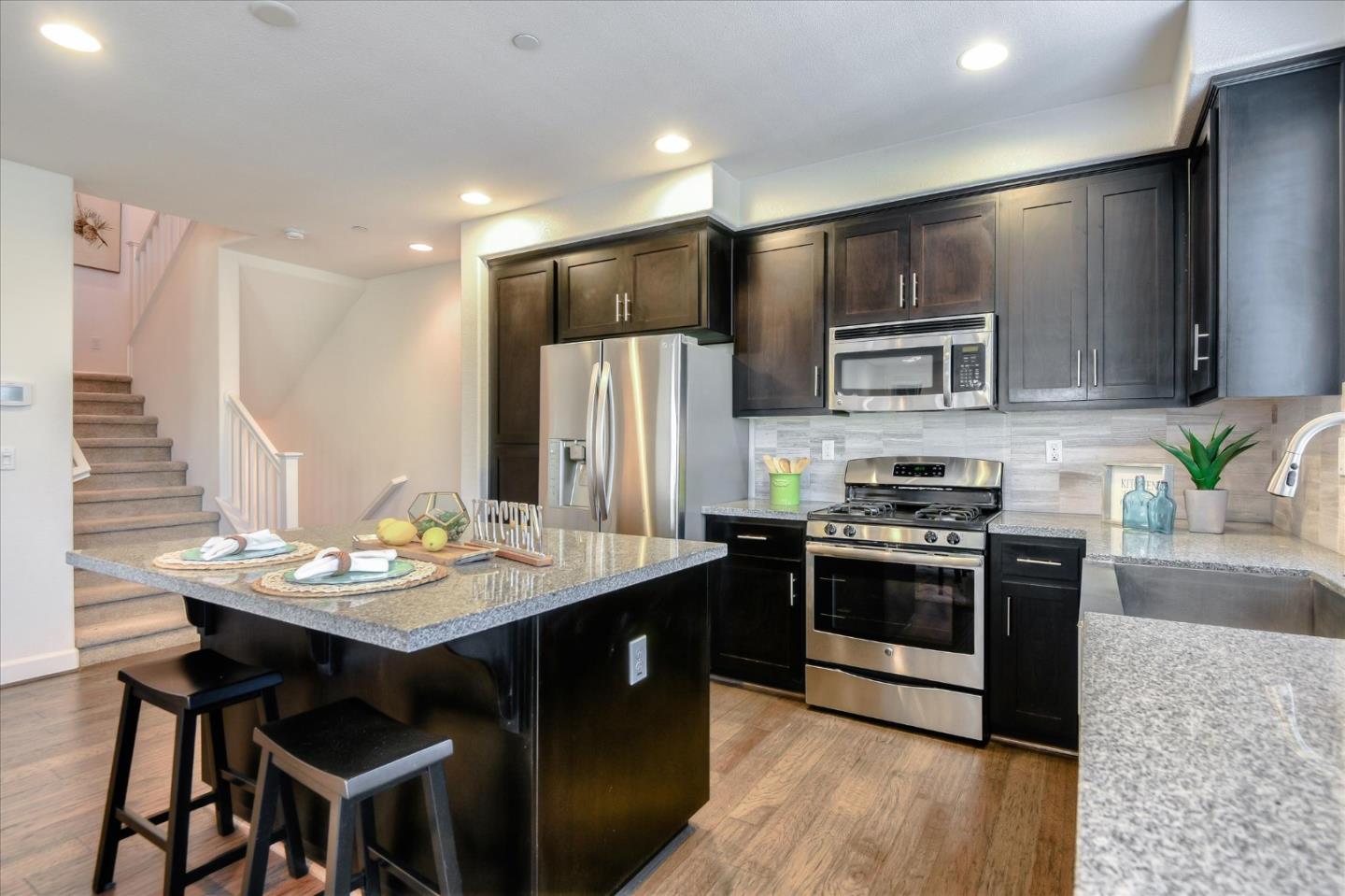 1915 McCandless Drive Milpitas, CA 95035 - Photo 18 of 28 a kitchen with stainless steel appliances kitchen island granite countertop a stove a sink a refrigerator and a microwave