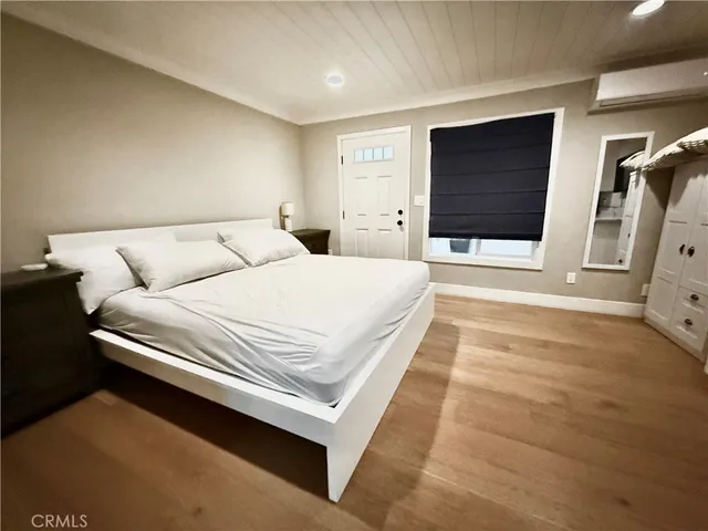a spacious bedroom with a bed and a flat screen tv