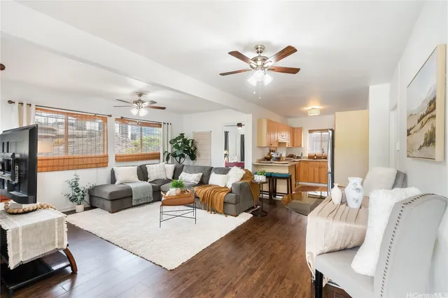 a living room with furniture kitchen view and a large window