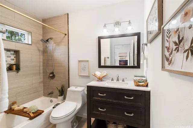 a bathroom with a toilet sink vanity granite and shower