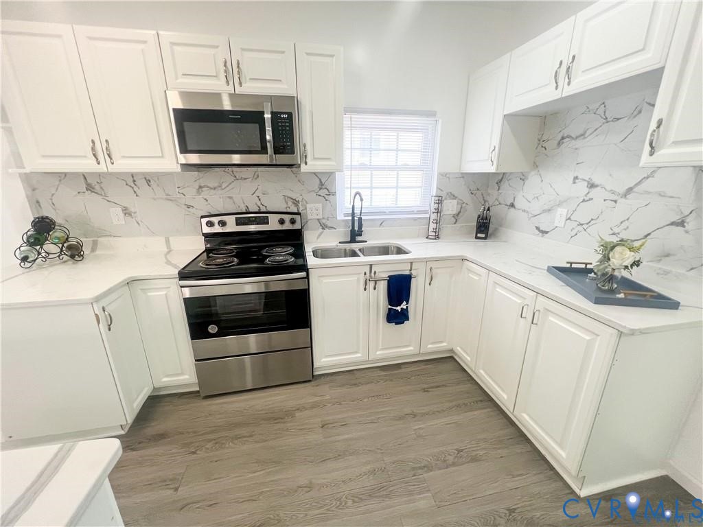 1340 Rome Street Petersburg, VA 23803 - Photo 11 of 35 a white kitchen with stainless steel appliances a stove a sink a microwave and cabinets