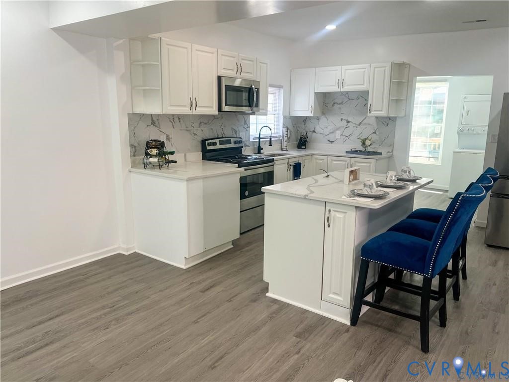 1340 Rome Street Petersburg, VA 23803 - Photo 12 of 35 a kitchen with a sink a stove a microwave and white cabinets