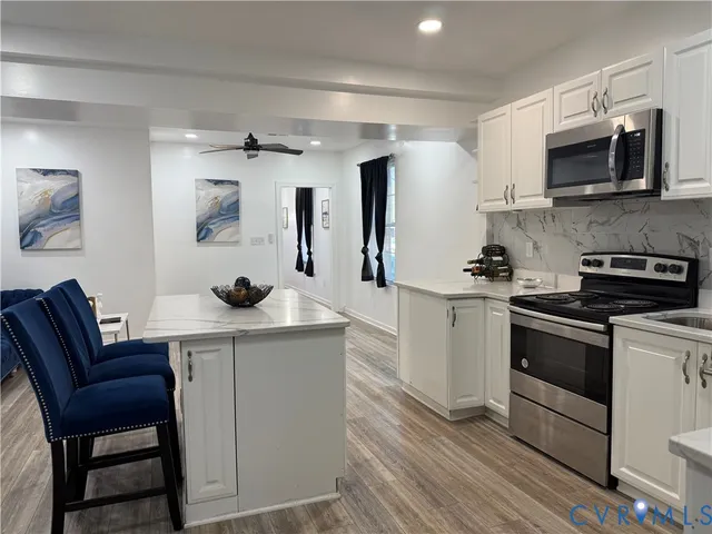 a kitchen with stainless steel appliances a stove microwave and cabinets