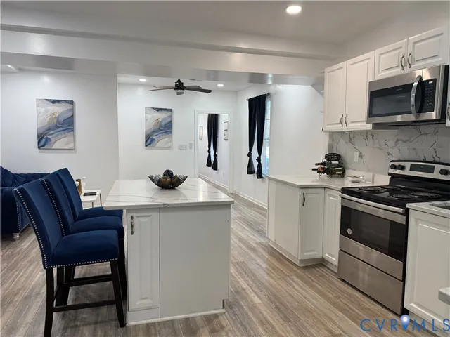 a kitchen with stainless steel appliances a stove a sink a microwave a refrigerator and cabinets