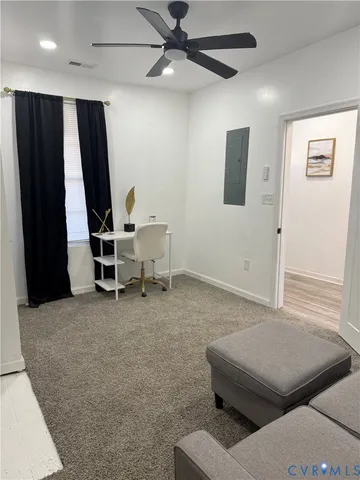 a living room with furniture and a ceiling fan