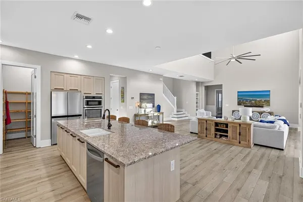 a large kitchen with a center island and stainless steel appliances
