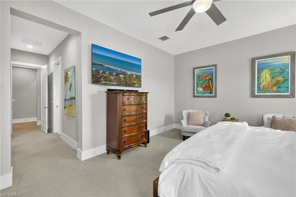 a bedroom with double bed and paintings on the wall