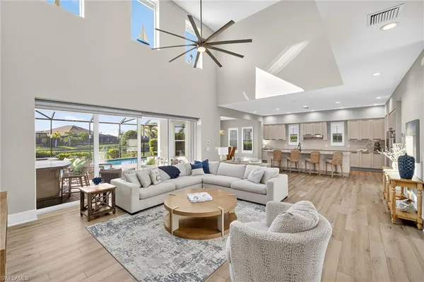 a living room with furniture and a large window with wooden floor
