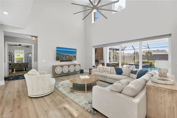 a living room with couches and a large mirror with wooden floor
