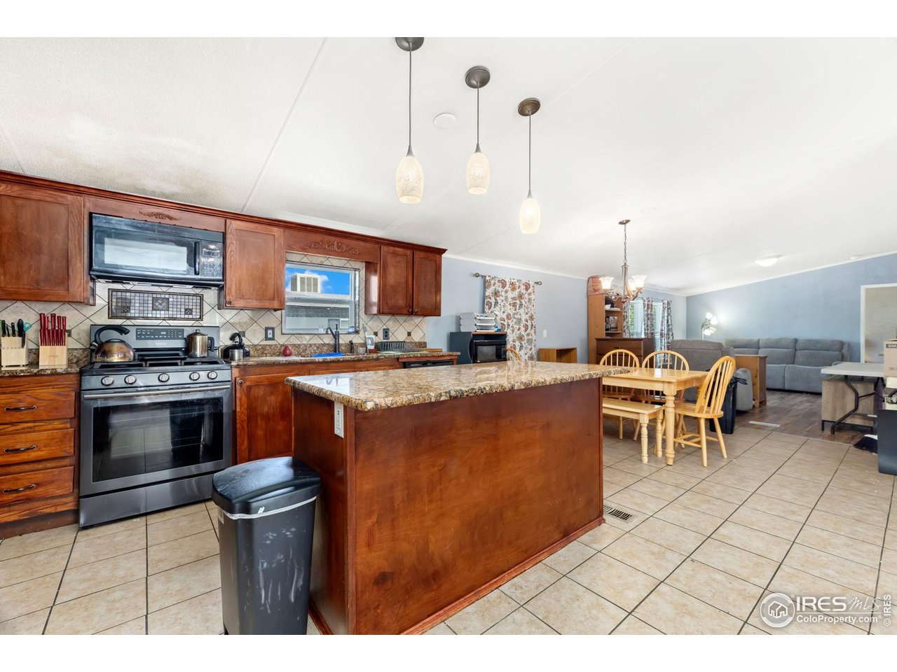218 Grape Street, Unit 29 Hudson, CO 80642 - Photo 11 of 26 a kitchen with stainless steel appliances kitchen island granite countertop a stove a sink and a refrigerator