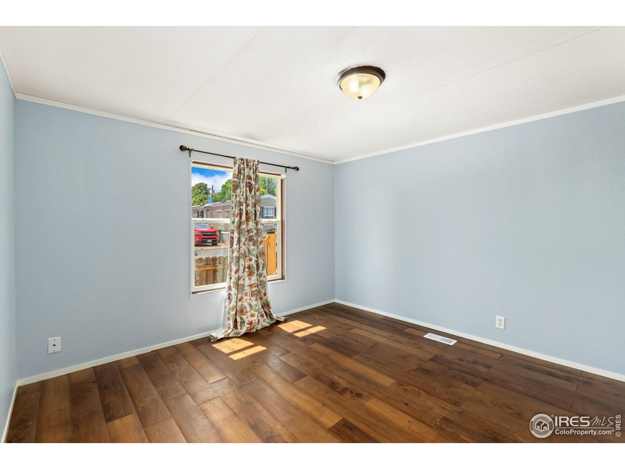 218 Grape Street, Unit 29 Hudson, CO 80642 - Photo 15 of 26 an empty room with wooden floor and windows