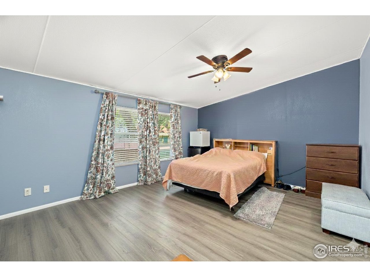 218 Grape Street, Unit 29 Hudson, CO 80642 - Photo 22 of 26 a spacious bedroom with a bed and a book shelf