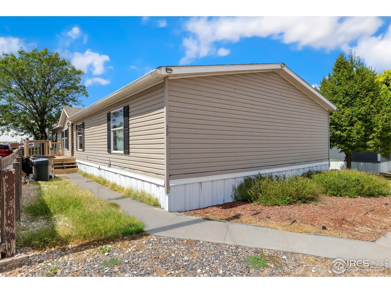 218 Grape Street, Unit 29 Hudson, CO 80642 - Photo 7 of 26 a view of a backyard with plants and a tree