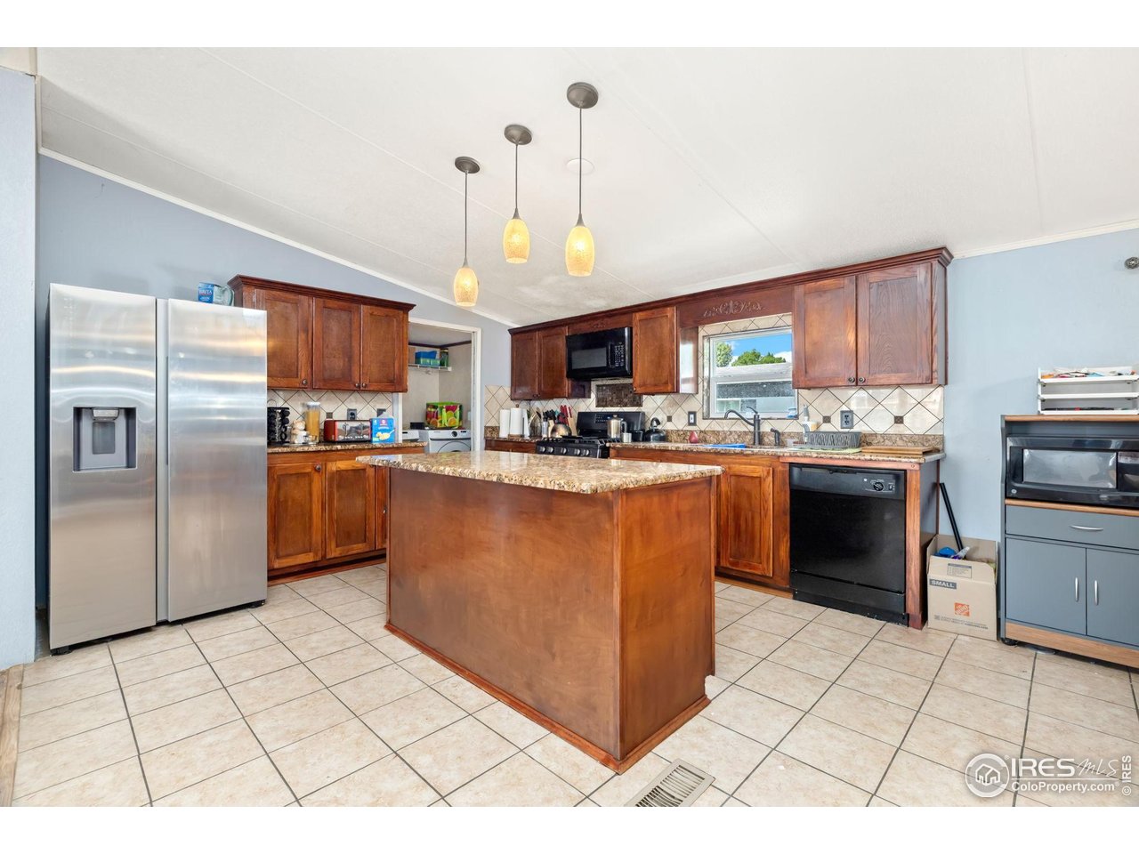 218 Grape Street, Unit 29 Hudson, CO 80642 - Photo 9 of 26 a kitchen with stainless steel appliances granite countertop a stove top oven a refrigerator a stove top oven and a sink with cabinets