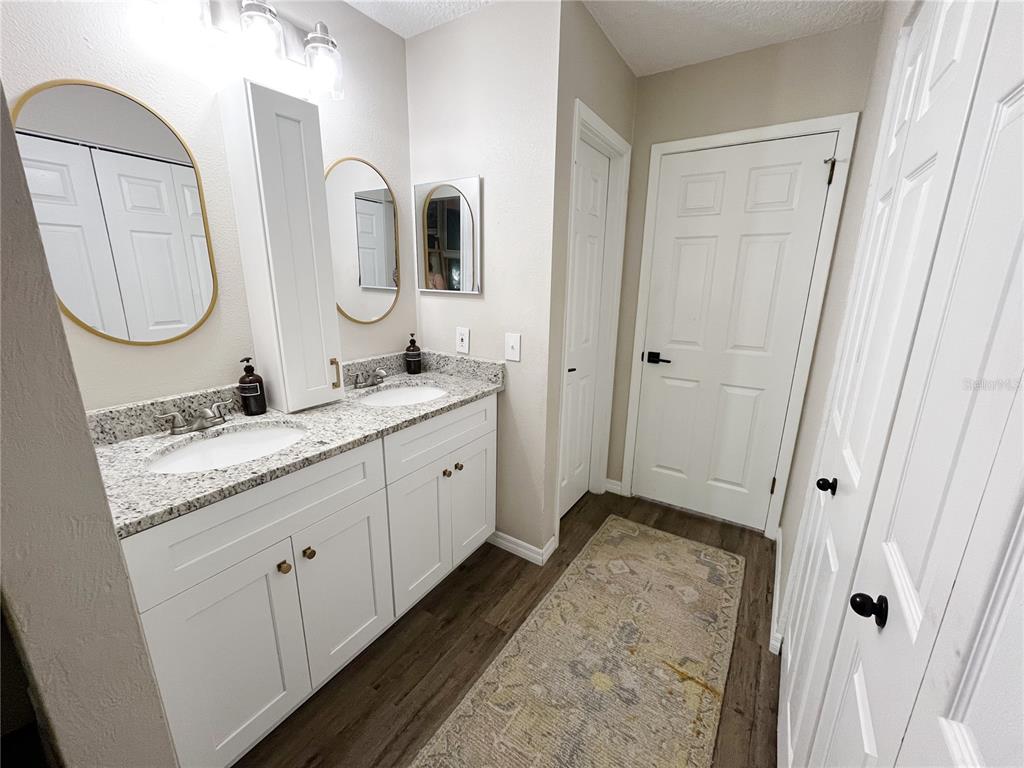 16 Raintree Court Ormond Beach, FL 32174 - Photo 10 of 37 a spacious bathroom with a granite countertop sink mirror and a