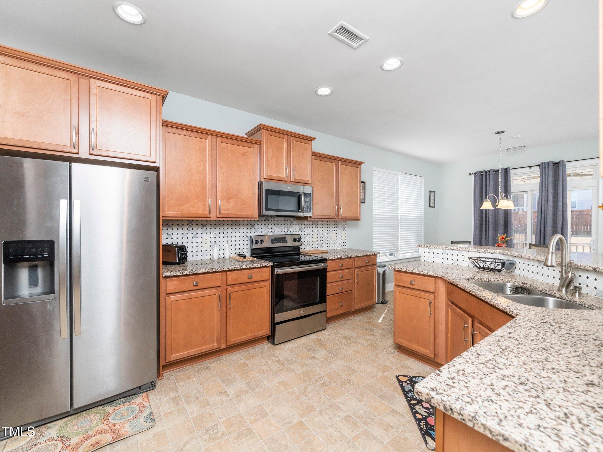 4508 Brintons Cottage Street Raleigh, NC 27616 - Photo 7 of 46 a kitchen with stainless steel appliances granite countertop a refrigerator stove microwave and sink