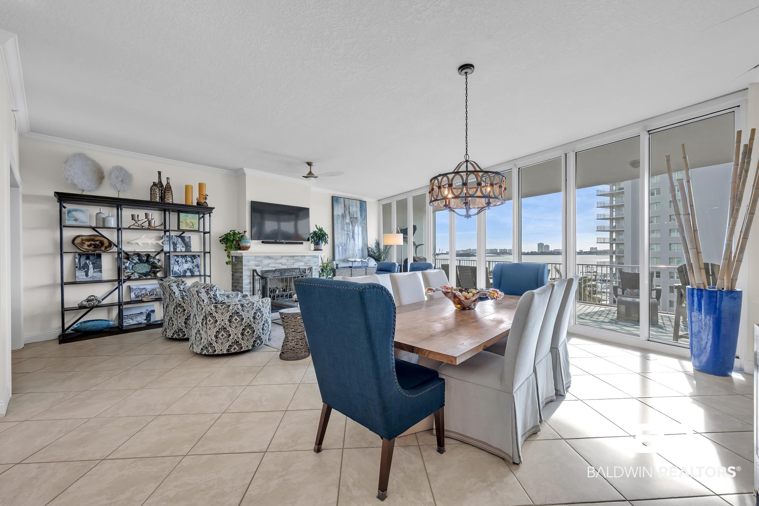 28250 Canal Road, Unit 307 Orange Beach, AL 36561 - Photo 22 of 56 Dining space featuring expansive windows, a fireplace, suspended lighting, ceiling fan, and light tile patterned floors