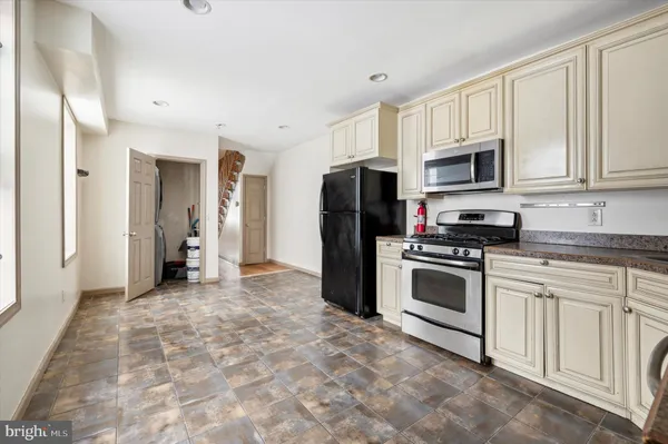 a kitchen with stainless steel appliances granite countertop a stove a refrigerator and a sink