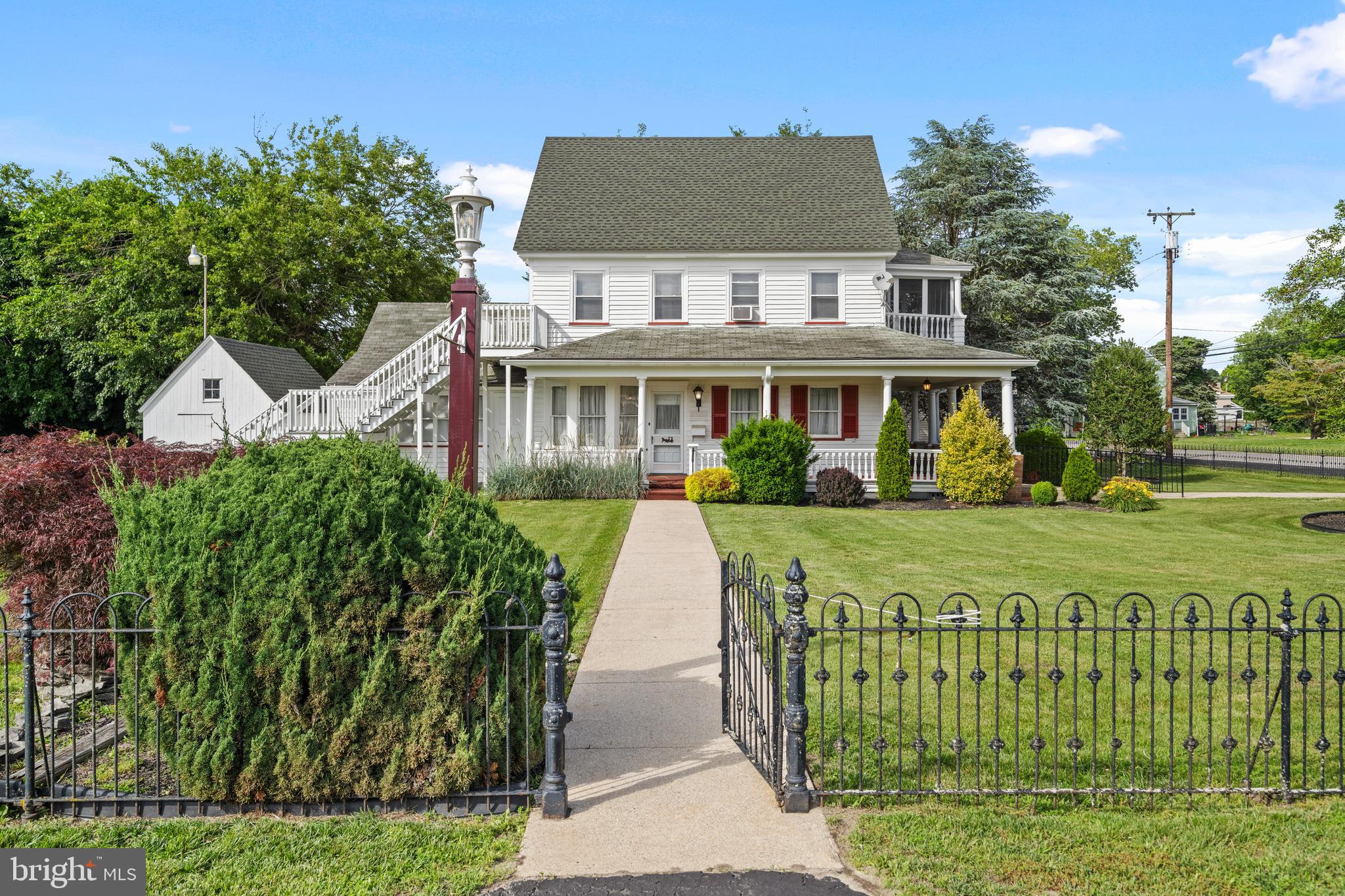 643 Main Street Leesburg, NJ 08327 - Photo 2 of 30 a view of a white house with a big yard and potted plants