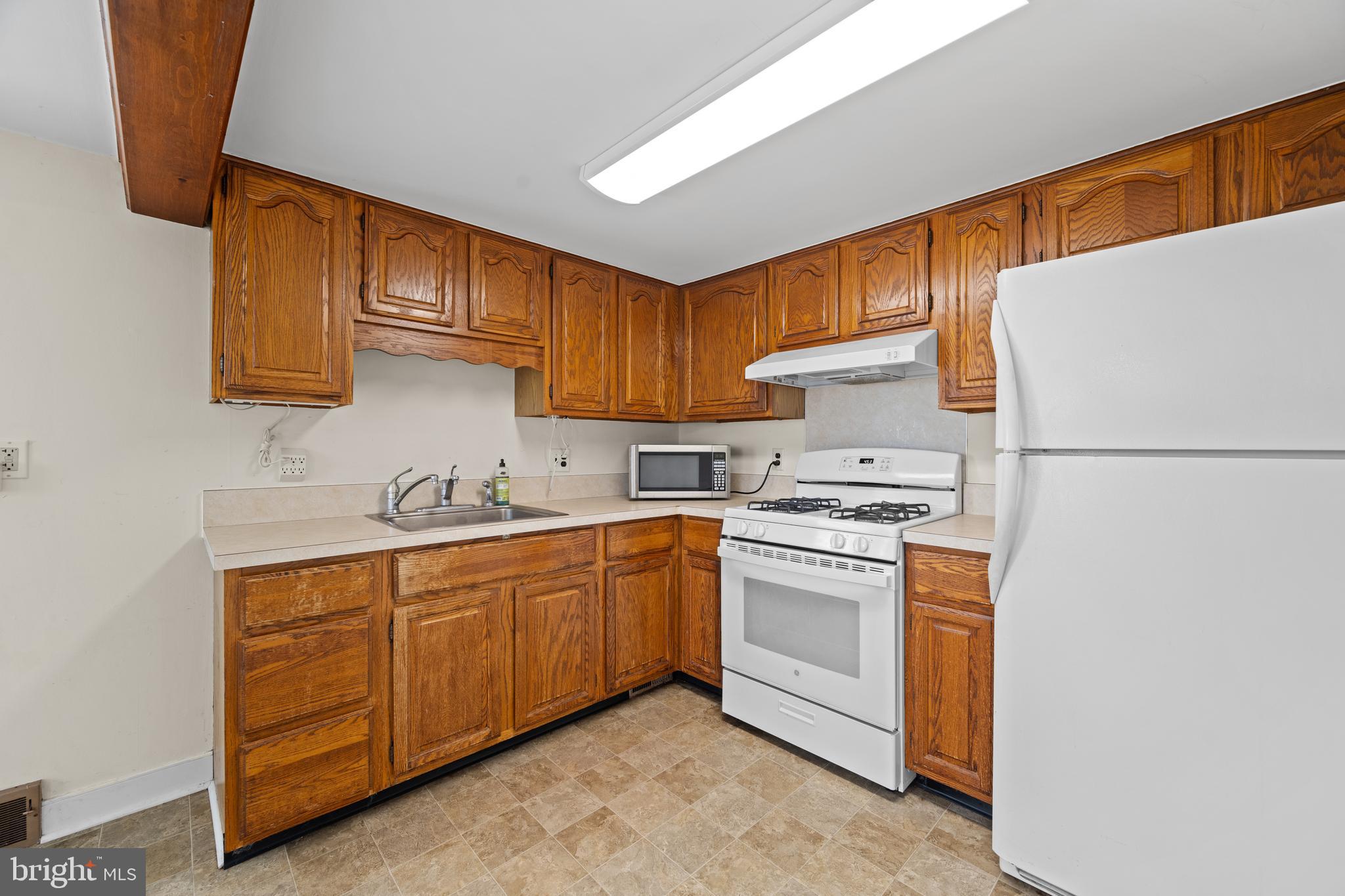 643 Main Street Leesburg, NJ 08327 - Photo 26 of 30 a kitchen with stainless steel appliances granite countertop a sink a stove a refrigerator with grey cabinets