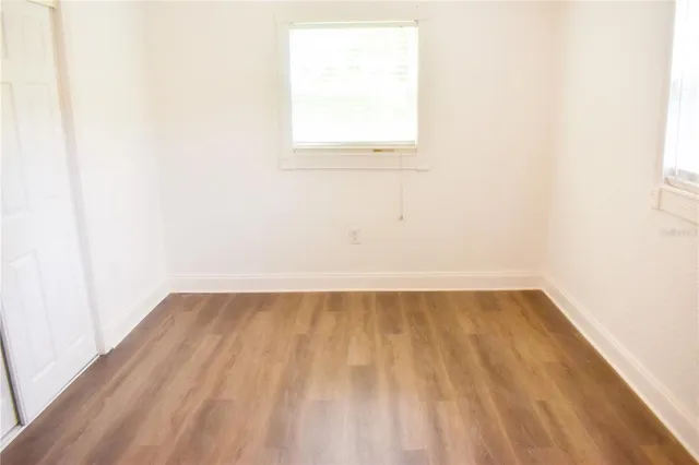 a view of a small space with wooden floor and a window