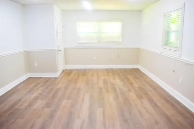 wooden floor in an empty room with a window