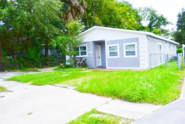 a view of a house with a yard and tree