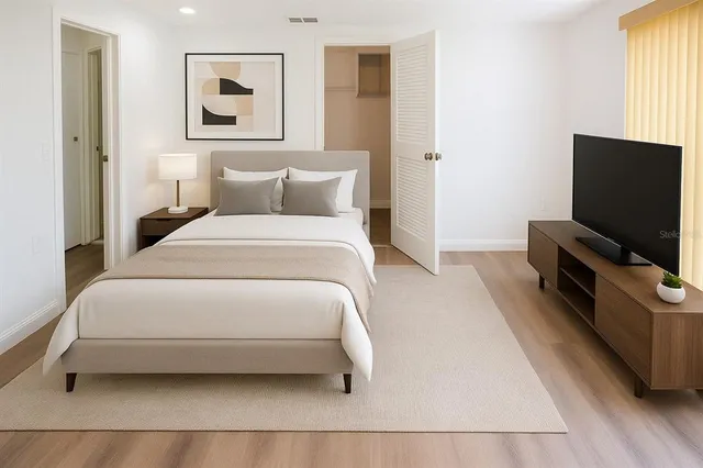 a bedroom with a bed and a flat screen tv