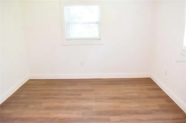 a view of a small space with wooden floor and a window