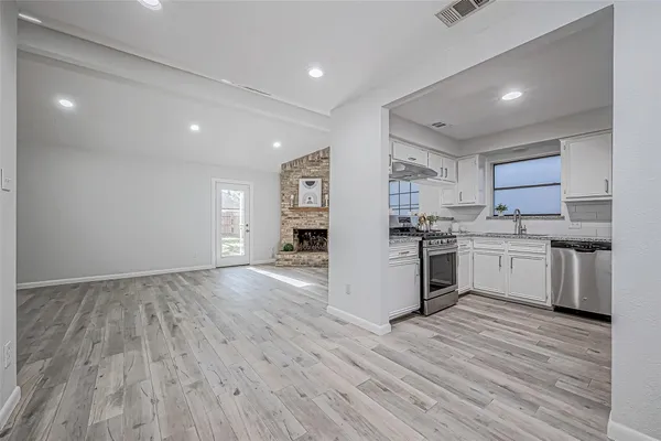 a kitchen with a refrigerator and white cabinets