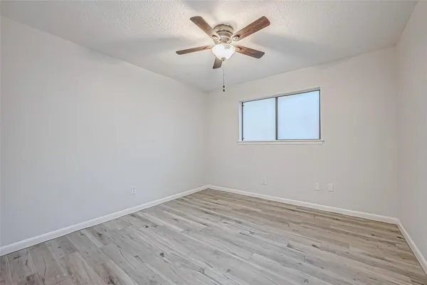 a view of a room with wooden floor and a ceiling fan