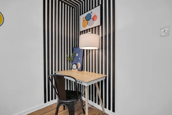 a view of a hallway with wooden floor and dining table