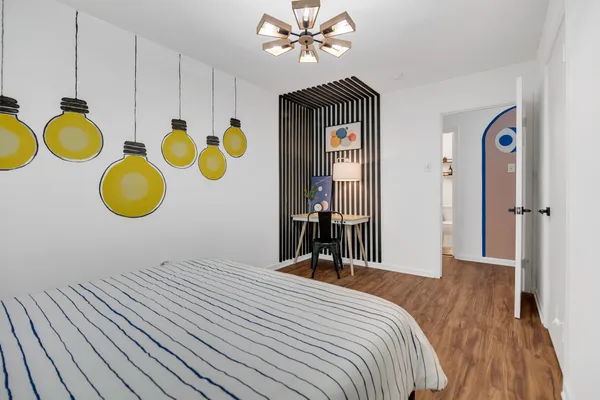 a bedroom with a bed and painting on the wall